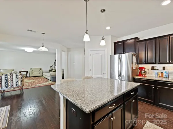 a kitchen with stainless steel appliances granite countertop a sink a refrigerator and a stove