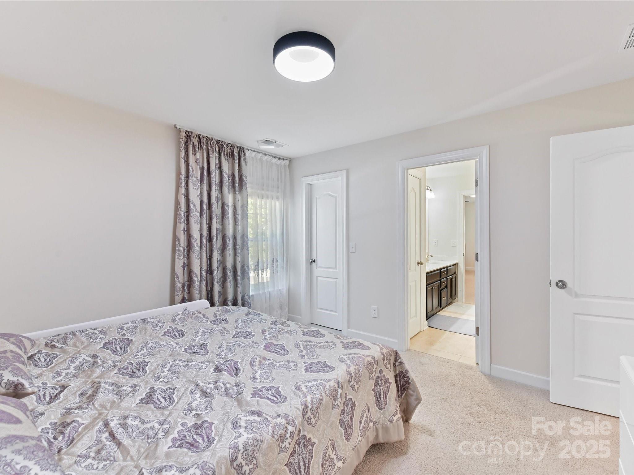 9890 Travertine Trail Davidson, NC 28036 - Photo 21 of 45 a bedroom with a large bed and a chandelier