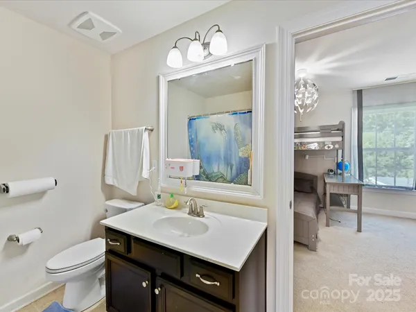 a bathroom with a sink a toilet a mirror and shower