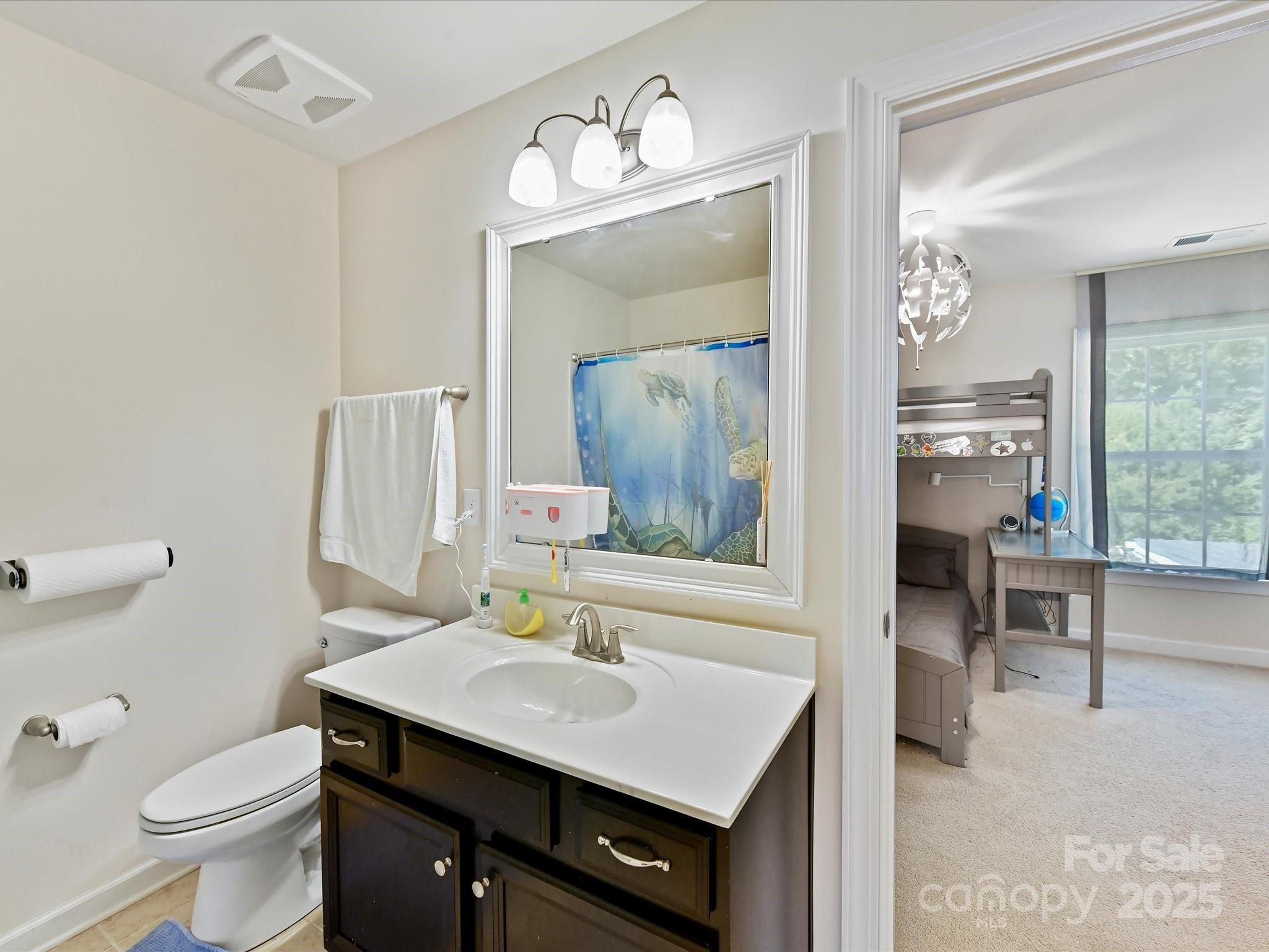 9890 Travertine Trail Davidson, NC 28036 - Photo 25 of 45 a bathroom with a sink a toilet a mirror and shower