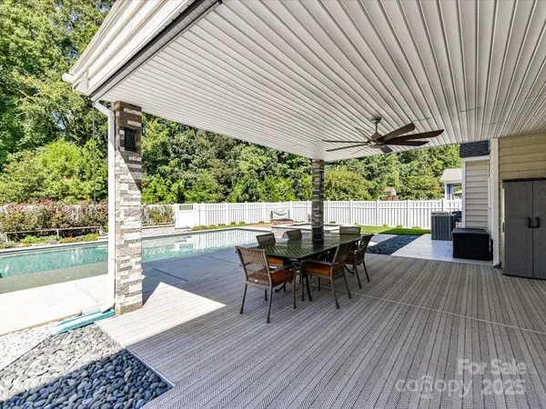 a view of a patio with table and chairs with wooden floor and fence