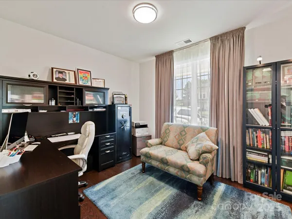 a living room with furniture a bookshelf and a window