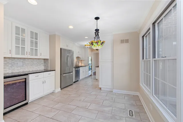 a kitchen with granite countertop a refrigerator and a stove top oven