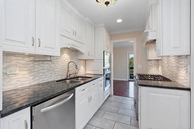 a kitchen with stainless steel appliances granite countertop a sink stove and cabinets