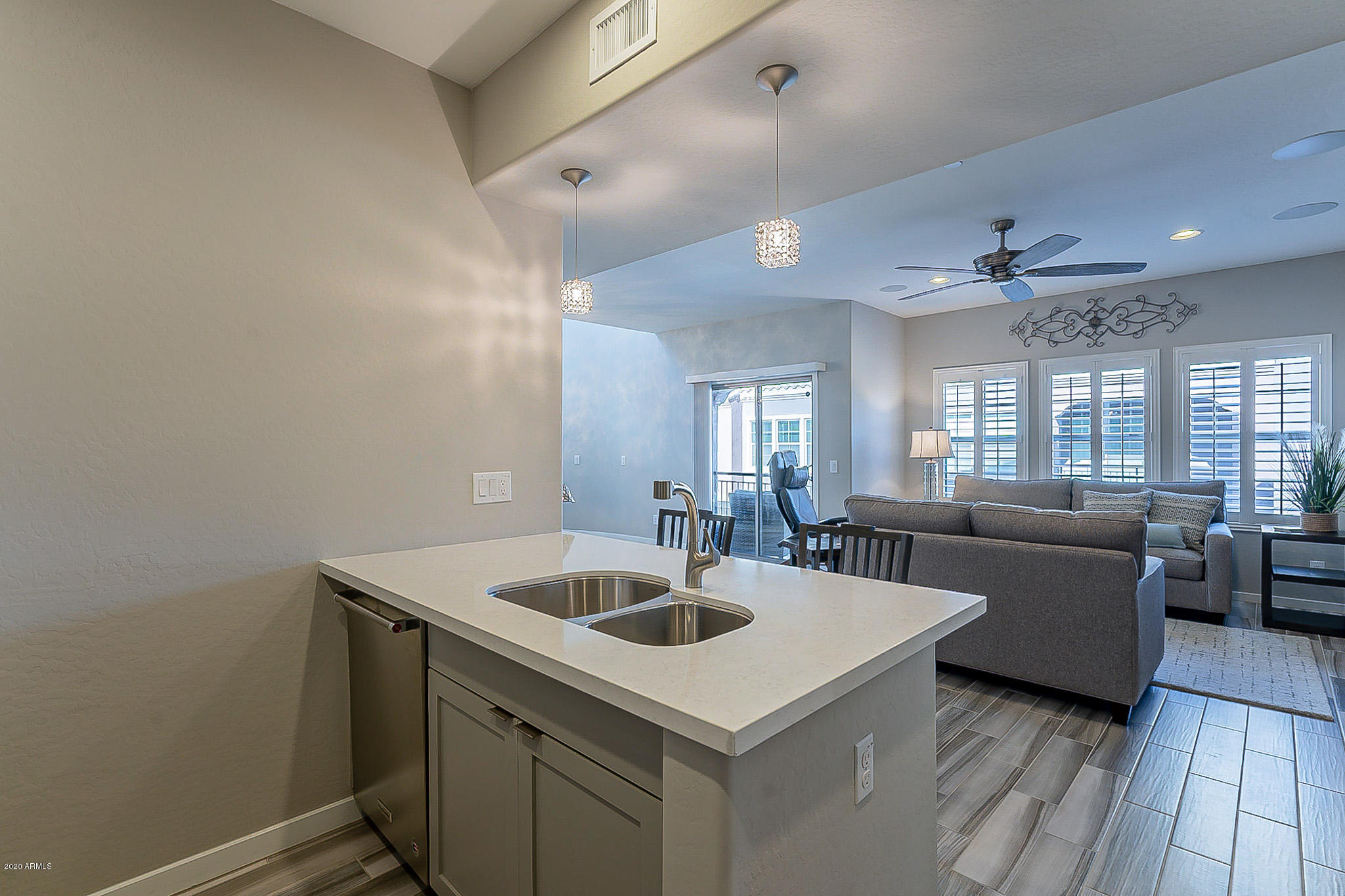 3935 East Rough Rider Road, Unit 1337 Phoenix, AZ 85050 - Photo 20 of 57 a kitchen with a sink dishwasher a dining table and chairs with wooden floor