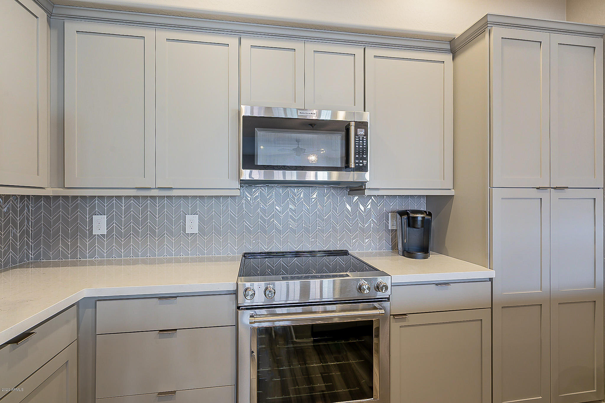 3935 East Rough Rider Road, Unit 1337 Phoenix, AZ 85050 - Photo 21 of 57 a kitchen with granite countertop white cabinets and white appliances