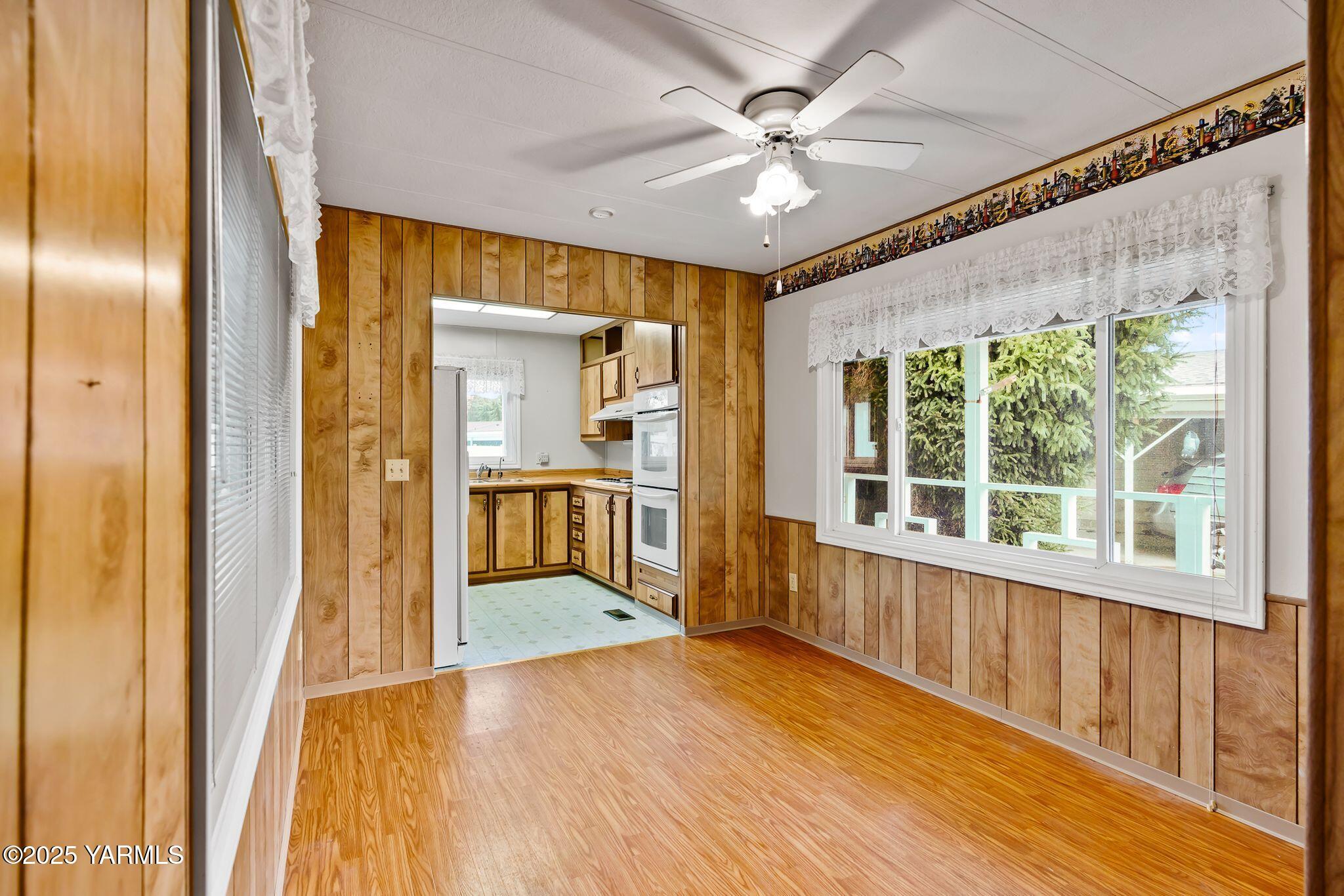 3701 Gun Club Road, Unit 43 Yakima, WA 98901 - Photo 5 of 29 a view of a big room with wooden floor a ceiling fan and windows