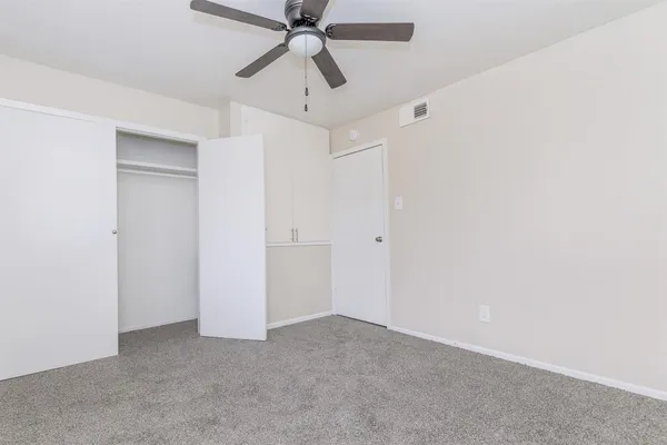 an empty room with chandelier fan