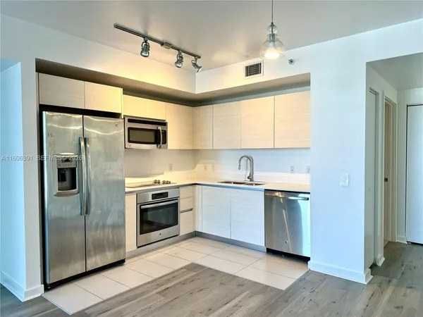 a kitchen with stainless steel appliances granite countertop a stove a sink and a refrigerator