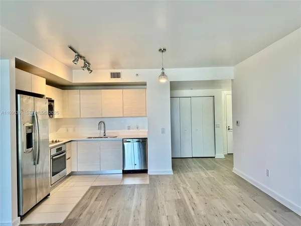a kitchen with a sink a refrigerator and cabinets