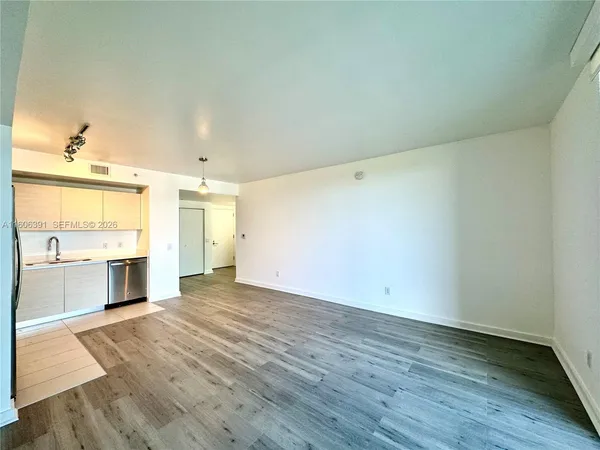 a view of an empty room and window and wooden floor