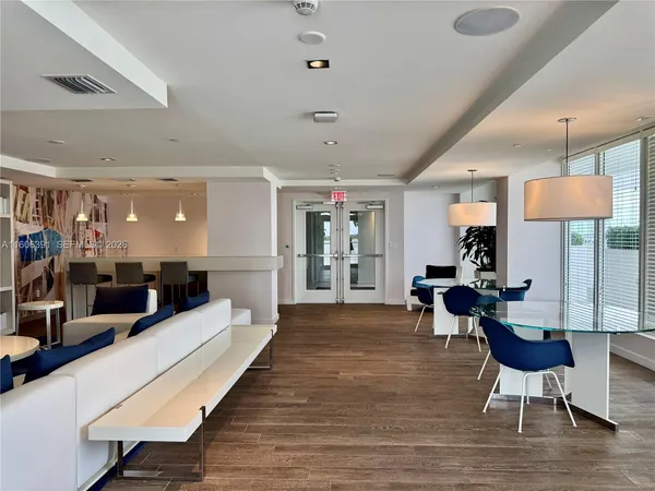 a large living room with furniture a flat screen tv and large wooden floor