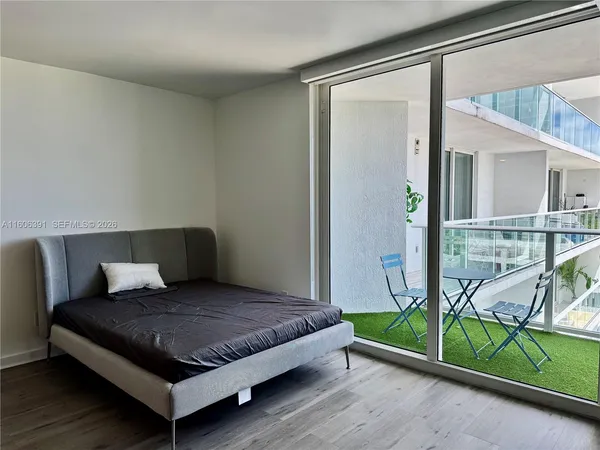 a bedroom with a bed and next to a window