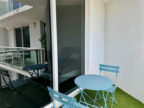 a view of a balcony with chairs and table