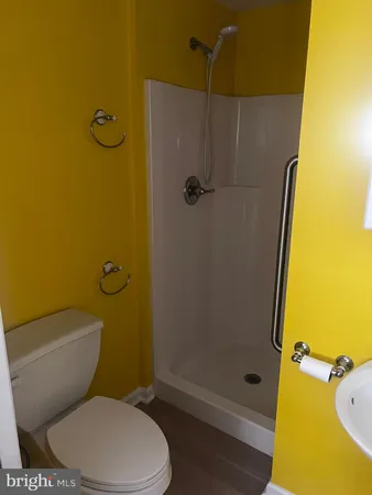 a white toilet sitting next to a bathroom sink and a shower