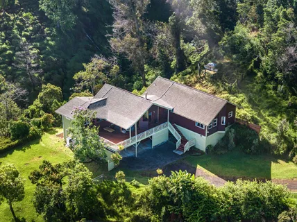 an aerial view of a house with swimming pool and a yard