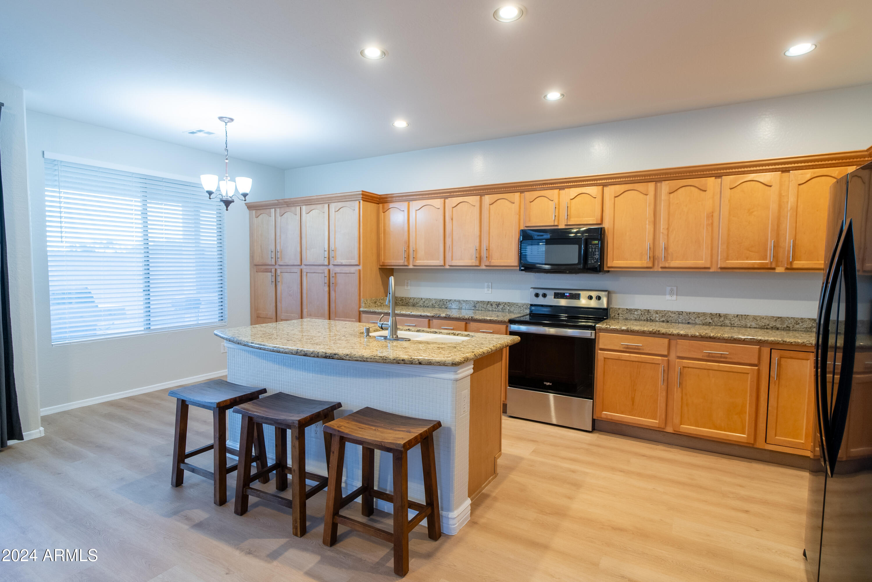 15471 West Statler Circle Surprise, AZ 85374 - Photo 11 of 32 a kitchen with granite countertop wooden floors appliances and window