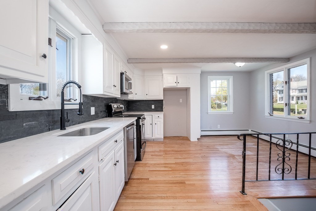 570 Canton Street Stoughton, MA 02072 - Photo 13 of 41 a kitchen with stainless steel appliances granite countertop a sink dishwasher a refrigerator and white cabinets with wooden floor
