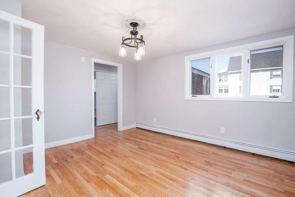570 Canton Street Stoughton, MA 02072 - Photo 16 of 41 a view of an empty room with wooden floor and a window