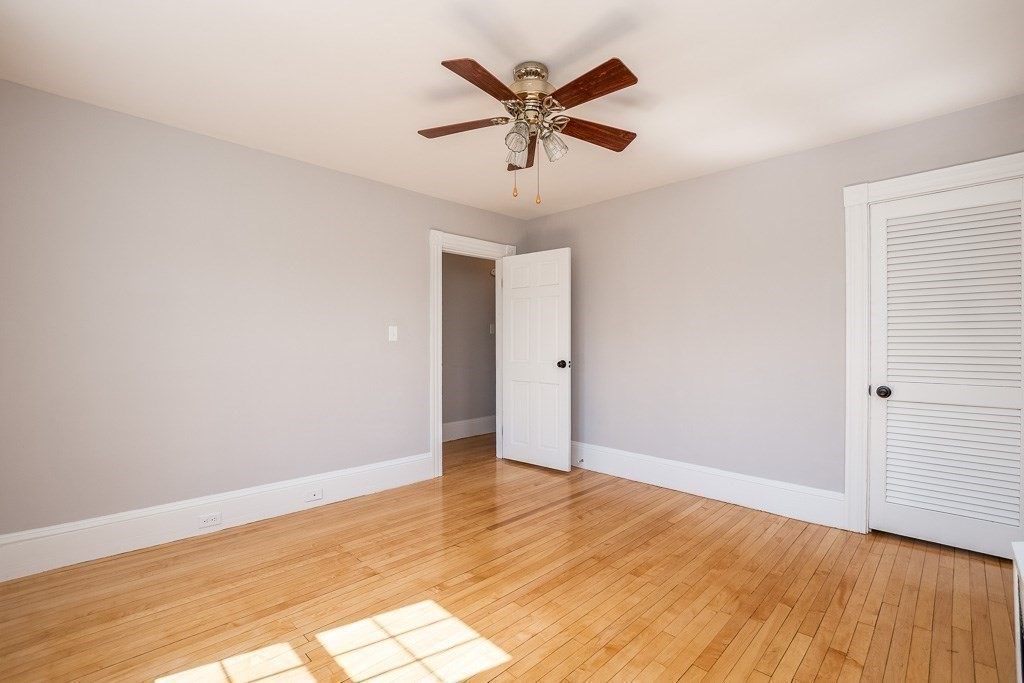 570 Canton Street Stoughton, MA 02072 - Photo 32 of 41 an empty room with wooden floor and ceiling fan