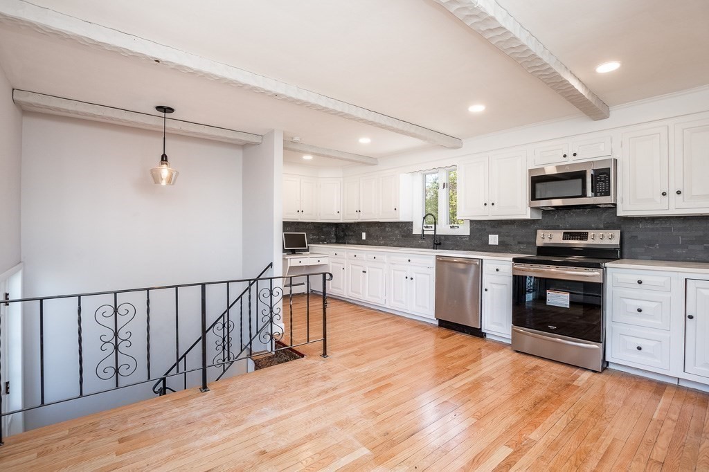 570 Canton Street Stoughton, MA 02072 - Photo 10 of 41 a kitchen with stainless steel appliances kitchen island granite countertop a sink cabinets and wooden floor