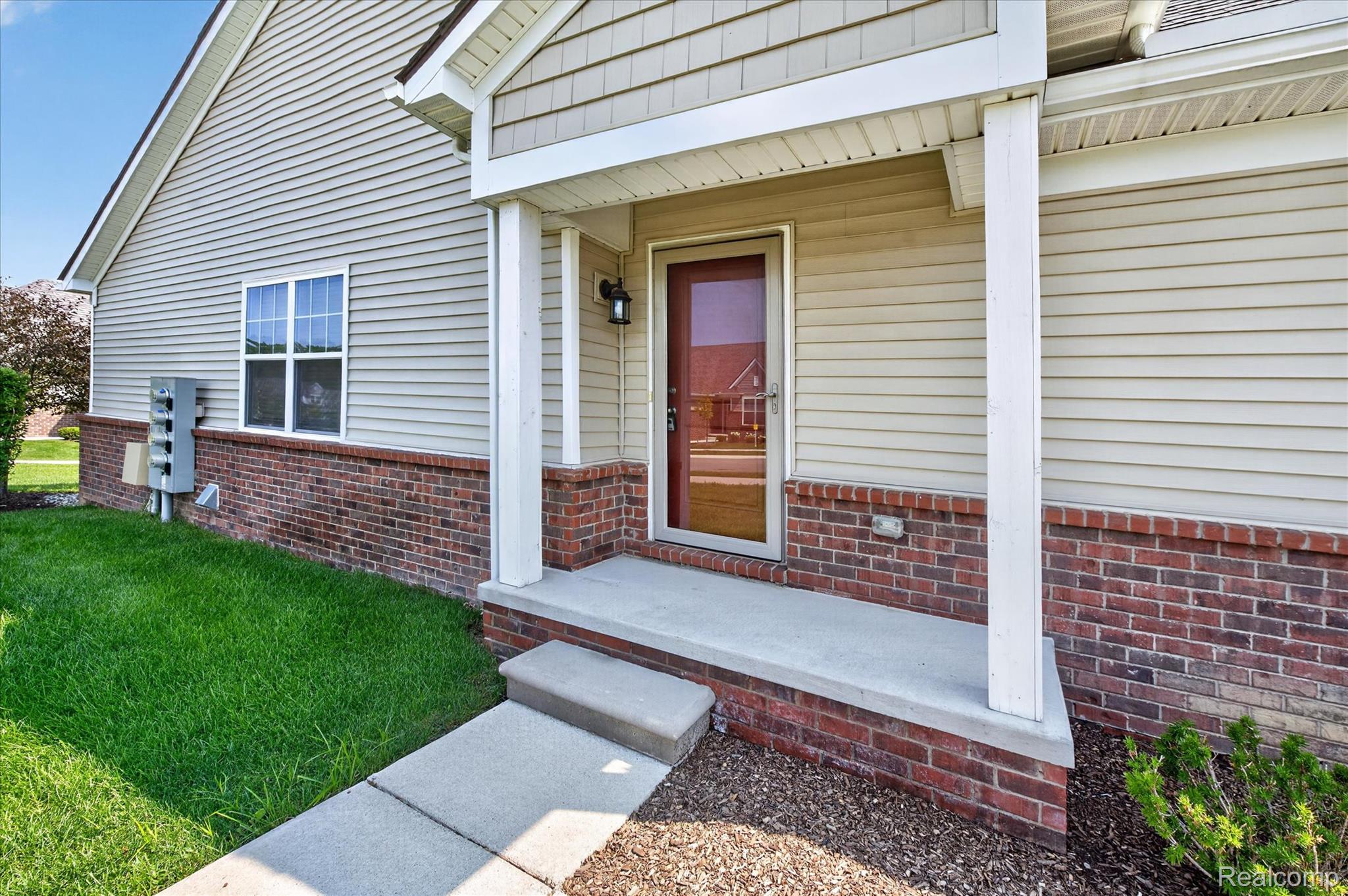 9911 Ridge Run Street Howell, MI 48855 - Photo 33 of 35 Covered entry with brick accents and storm door.