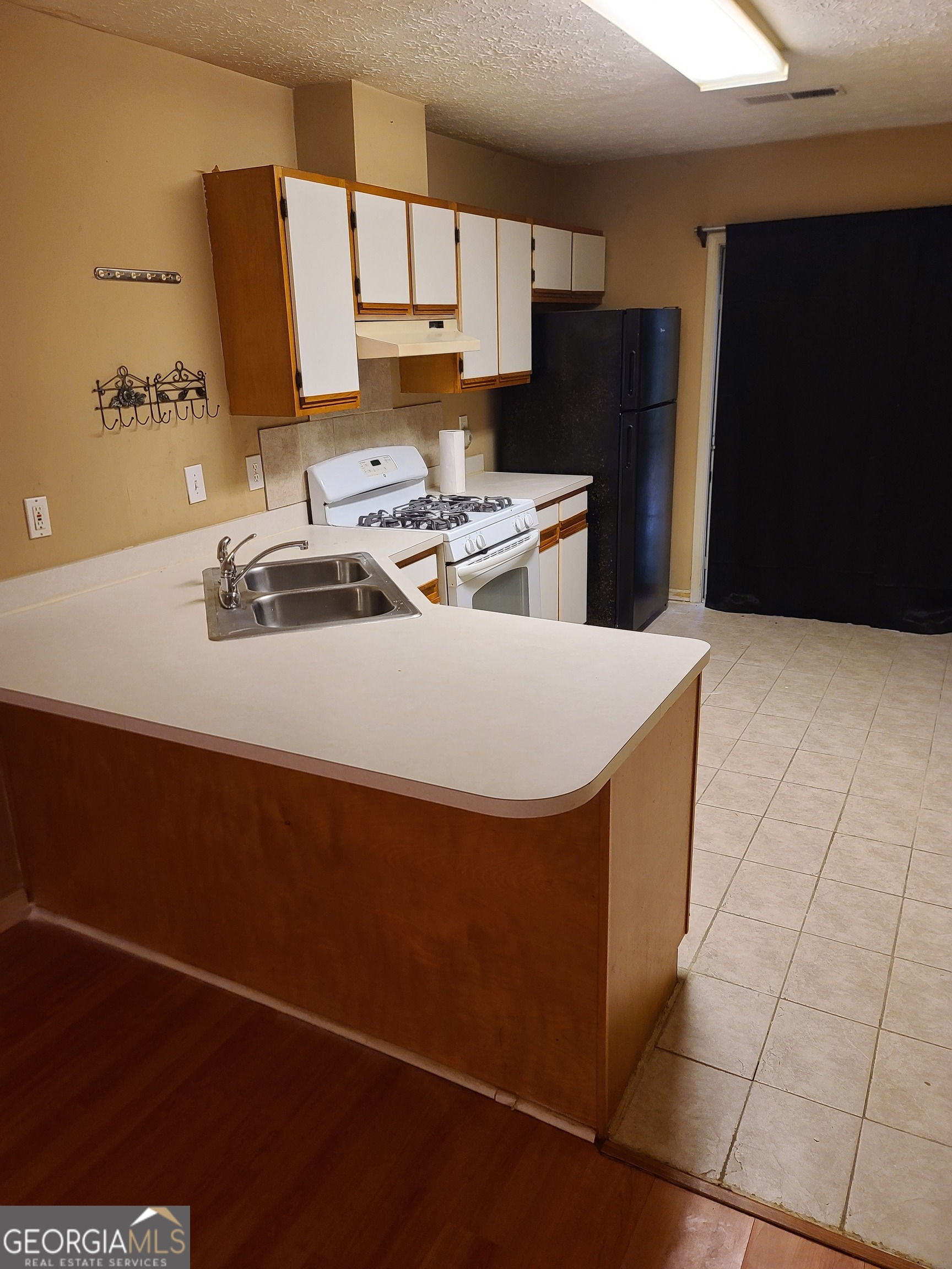 807 Boston Common Atlanta, GA 30349 - Photo 5 of 9 a kitchen with stainless steel appliances a sink a refrigerator and a stove