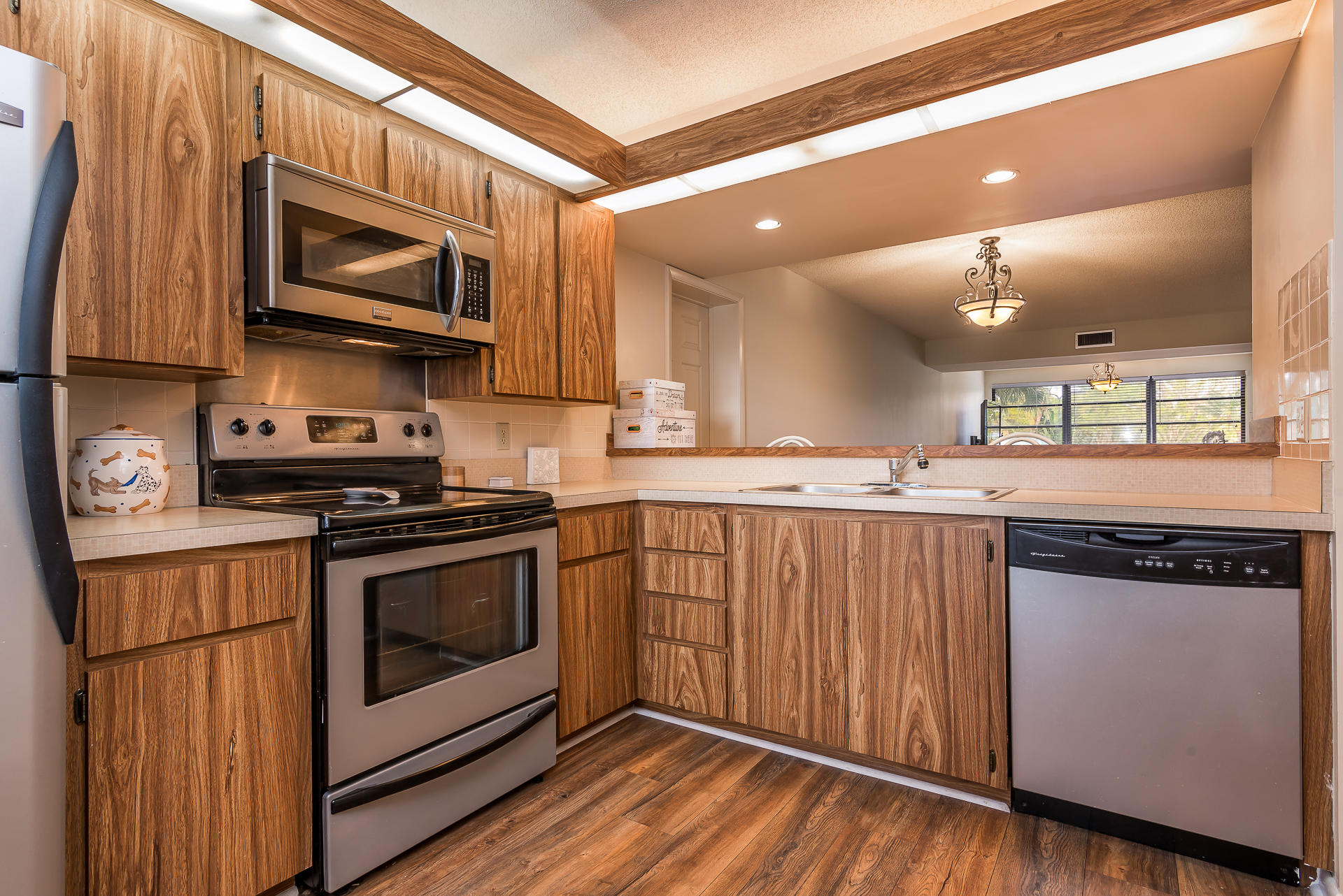 6109 Balboa Circle, Unit 206 Boca Raton, FL 33433 - Photo 7 of 18 a kitchen with stainless steel appliances granite countertop a stove a sink and a microwave