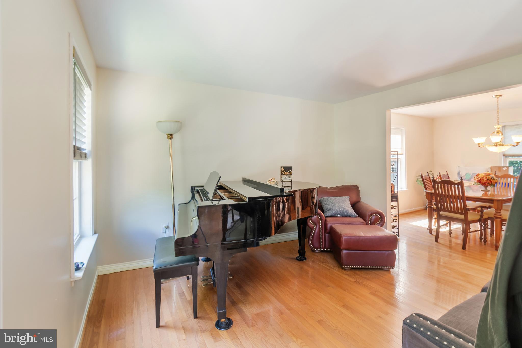3040 Jones Road Dunkirk, MD 20754 - Photo 21 of 67 a living room with furniture a dining table and a piano next to a window