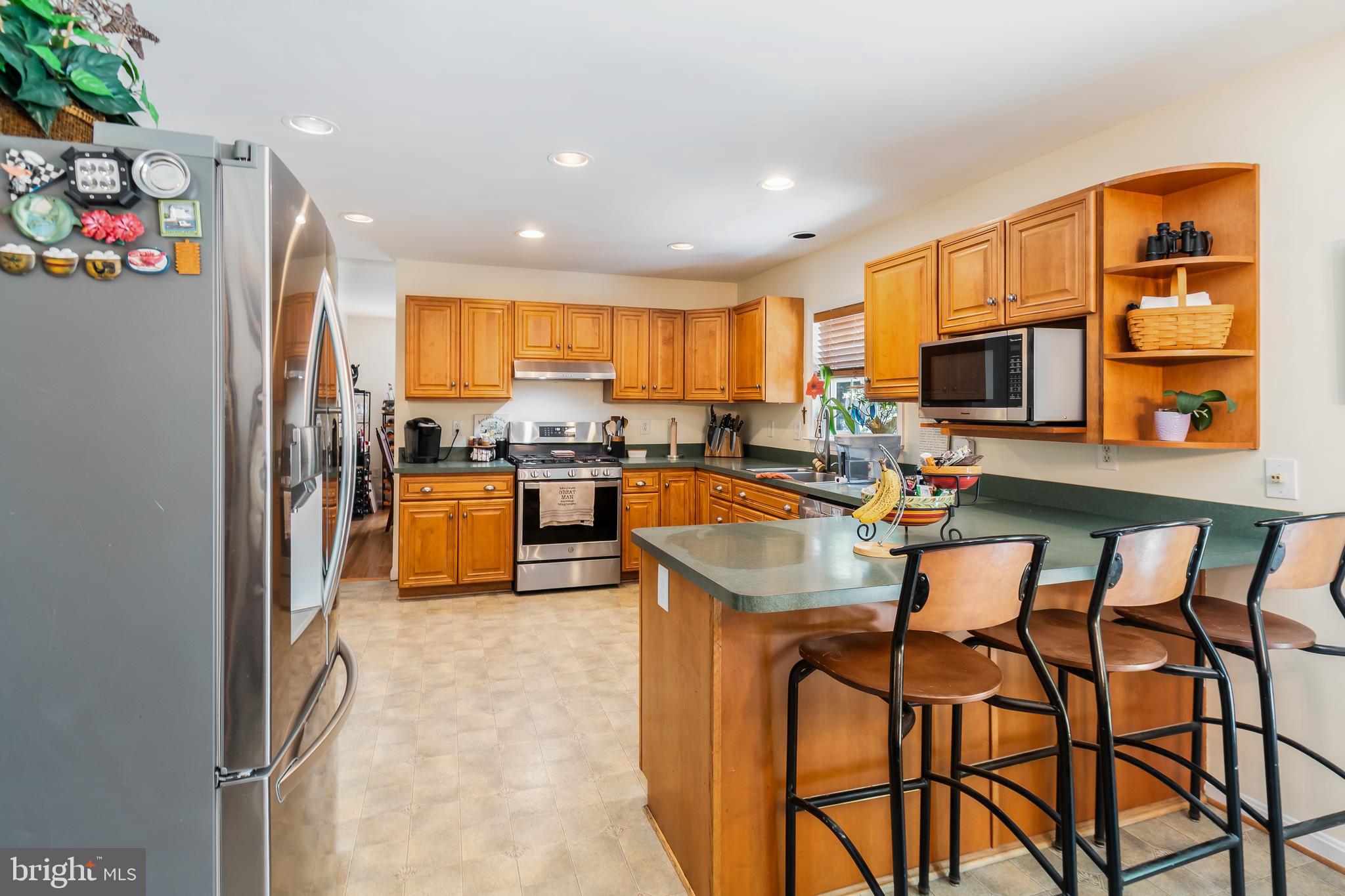 3040 Jones Road Dunkirk, MD 20754 - Photo 28 of 67 a kitchen with granite countertop lots of wooden cabinets a sink a stove and a refrigerator