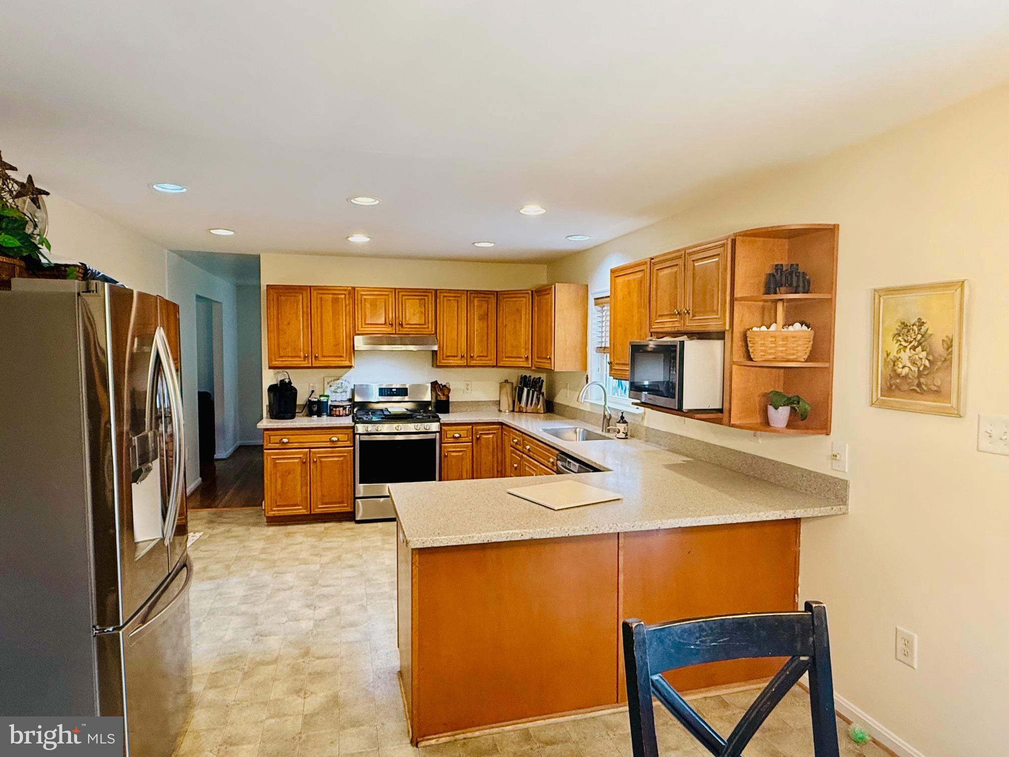3040 Jones Road Dunkirk, MD 20754 - Photo 6 of 67 a kitchen with stainless steel appliances granite countertop a refrigerator a sink a stove and a refrigerator with wooden floor