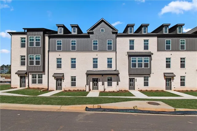 front view of a brick house with a yard