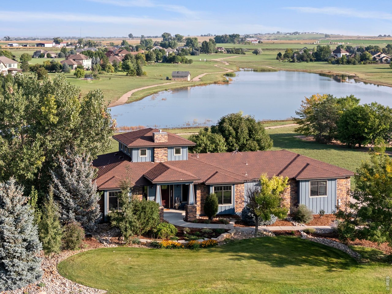 an aerial view of a house with garden space and lake view