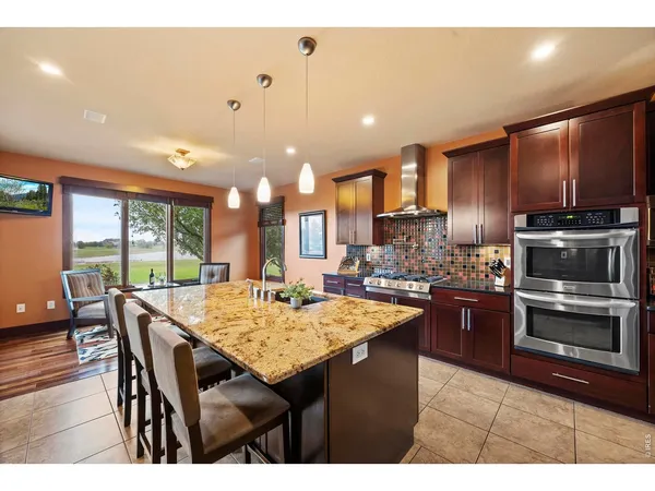 a kitchen with a stove a refrigerator and wooden floor