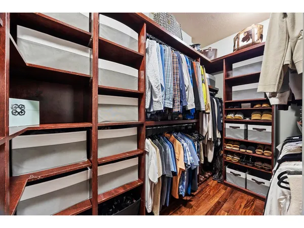 a view of walk in closet with clothes and shoes