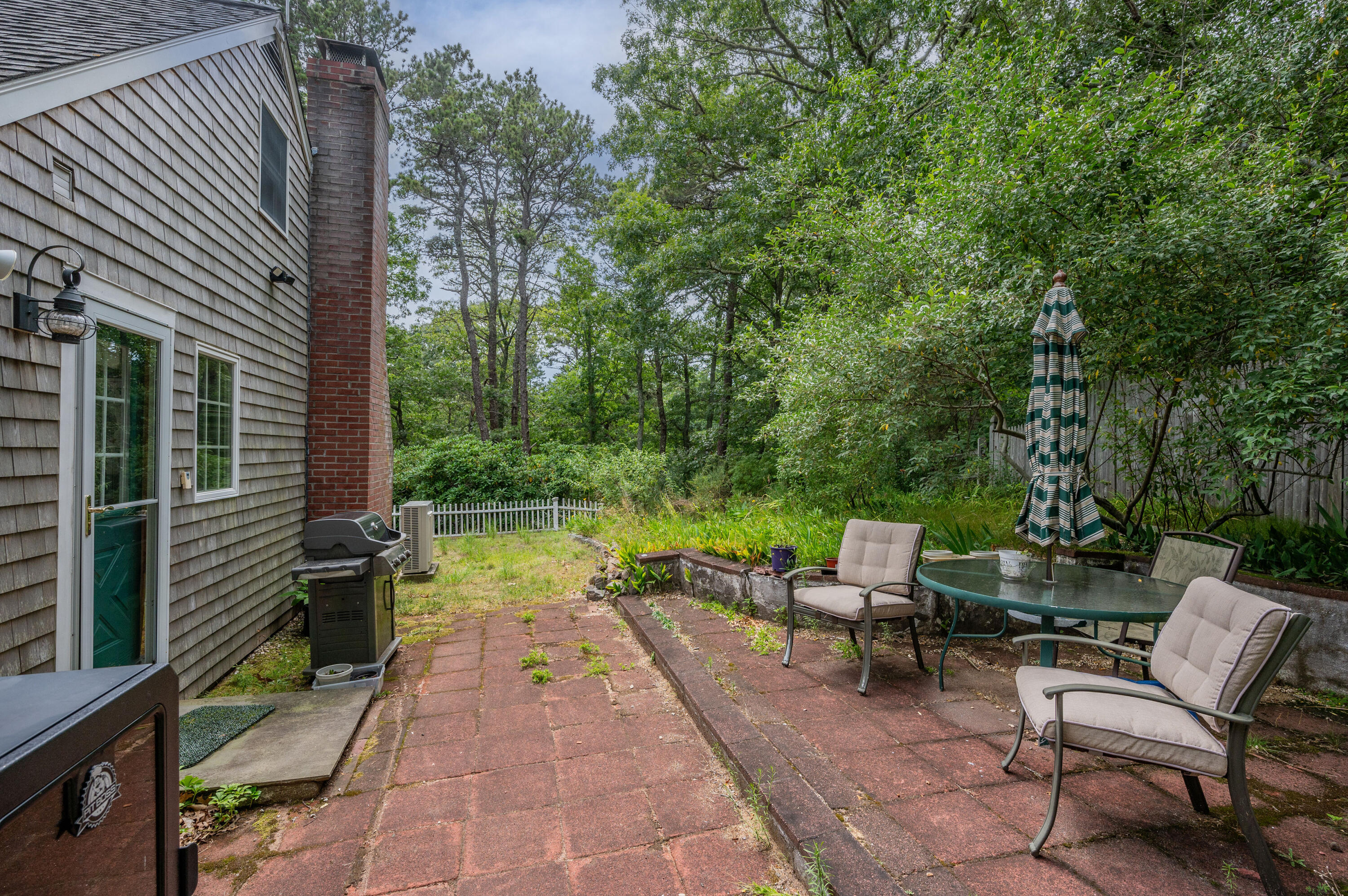80 Jonathans Way Brewster, MA 02631 - Photo 28 of 34 a view of a patio with a table and chairs next to a yard