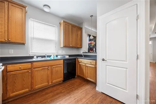 a kitchen with stainless steel appliances granite countertop a refrigerator a sink and dishwasher with wooden floor