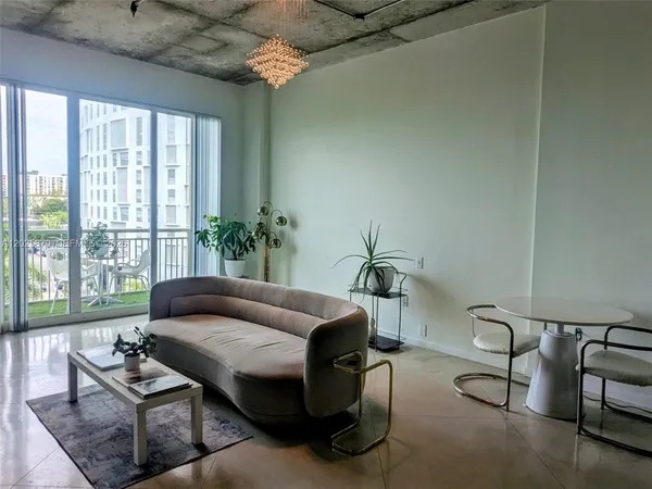 a living room with furniture and a floor to ceiling window