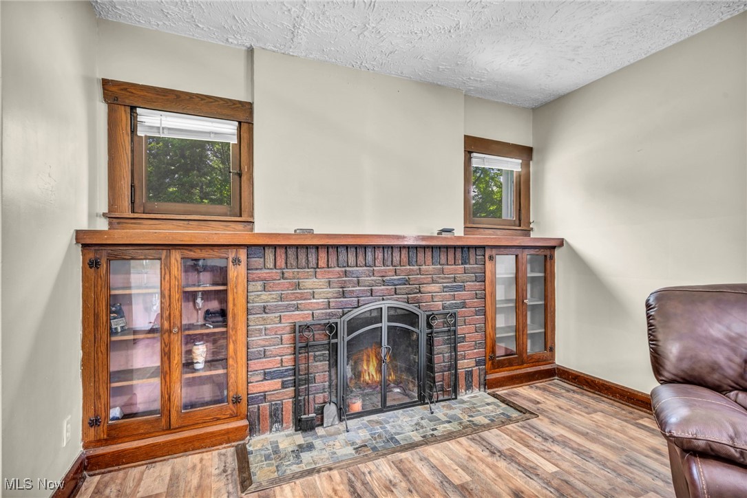 1425 Keefer Road Girard, OH 44420 - Photo 12 of 37 Living room featuring wood finished floors, a textured ceiling, and a fireplace