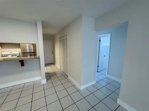 a view of a kitchen with white cabinets and refrigerator