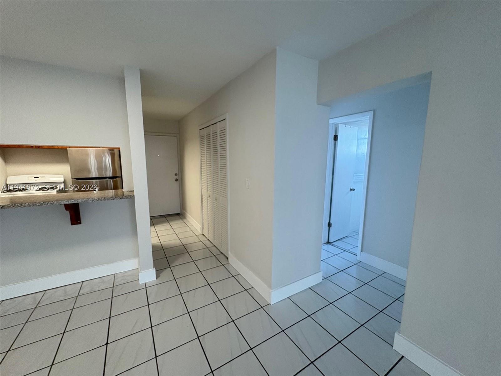 505 Northeast 30th Street, Unit 506 Miami, FL 33137 - Photo 4 of 29 a view of a kitchen with white cabinets and refrigerator