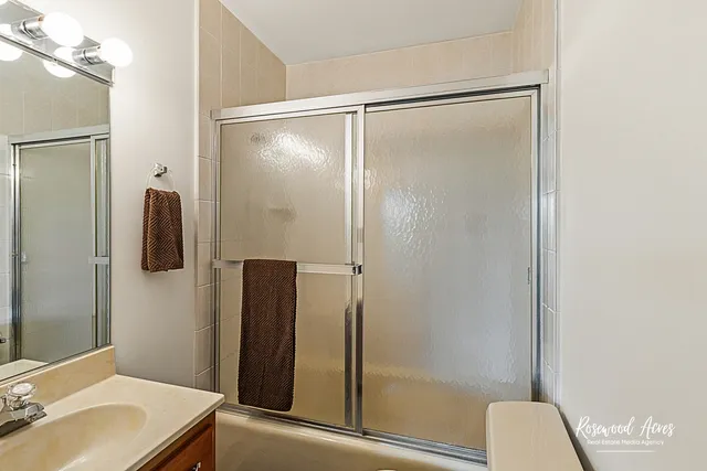 a bathroom with a granite countertop sink a mirror and a bathtub
