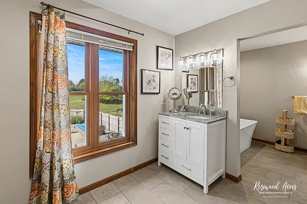 a spacious bathroom with a granite countertop sink a toilet and a mirror