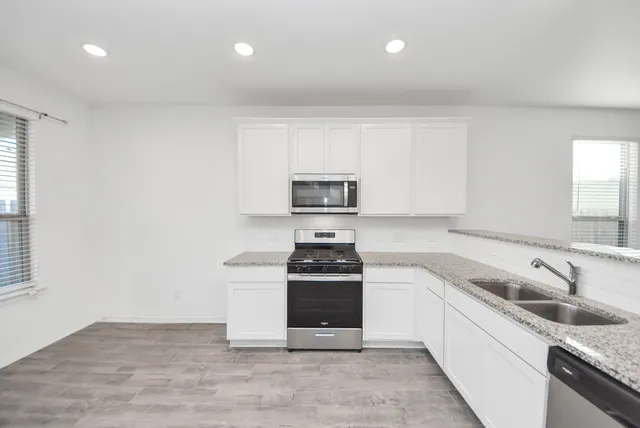 a kitchen that has a sink and a stove top oven