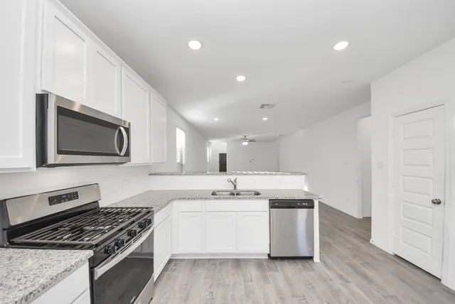a large kitchen with a refrigerator and a sink