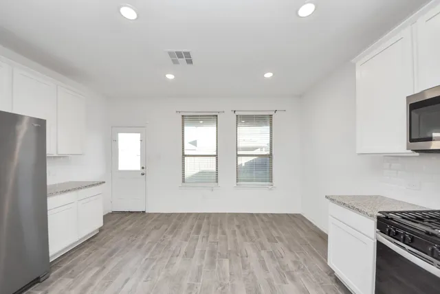 a kitchen with stainless steel appliances granite countertop a sink a stove a microwave and cabinets