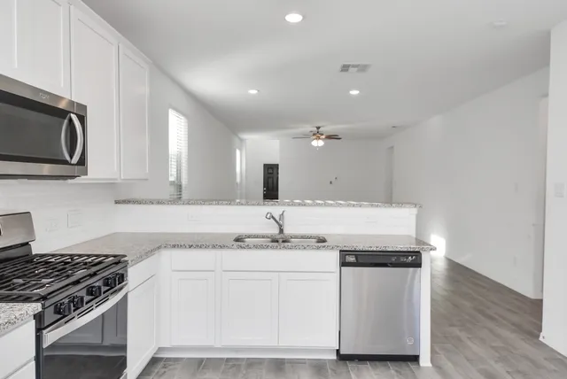 an empty room with windows and ceiling fan