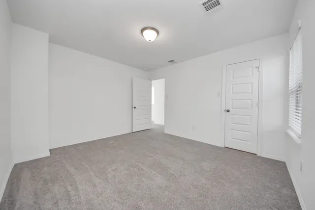 an empty room with windows and closet