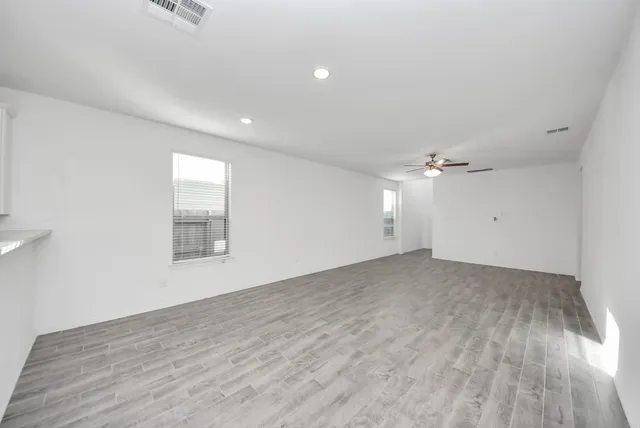 a view of empty room with wooden floor