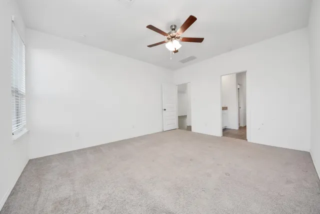 a view of a big room with closet and ceiling fan